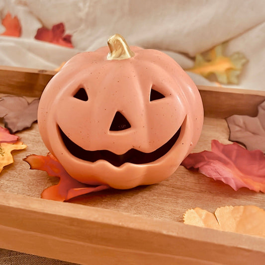 ceramic pumpkin on a wooden tray with autumn leaves