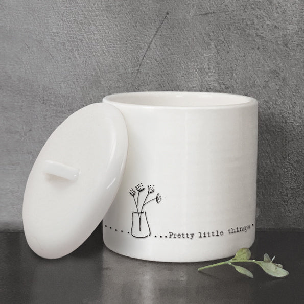 Pretty little things white pot with lid on the side and grey background