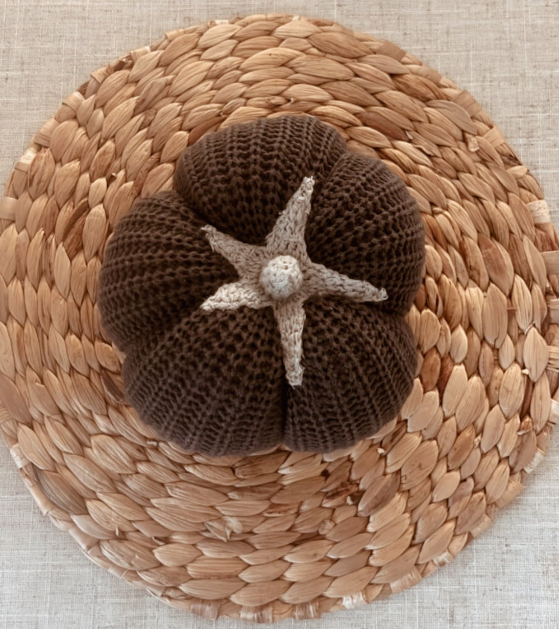 small black pumpkin on a rattan placemat