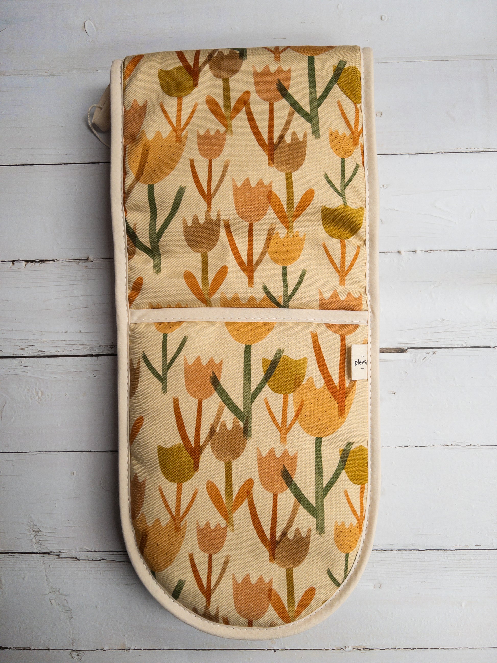 Cream Tulip Oven Glove on a White Wood Background