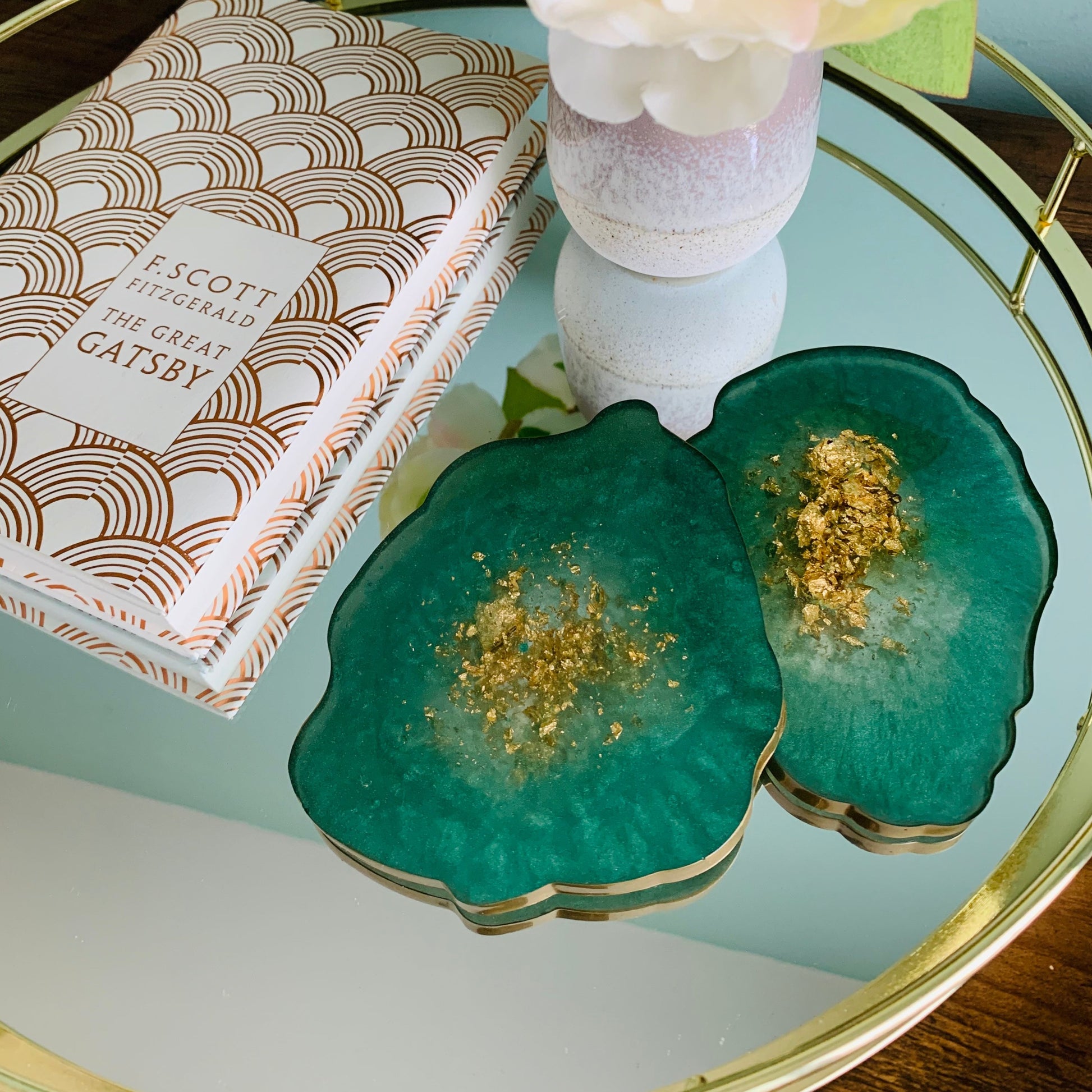 Emerald Green and gold resin coaster on a gold mirror tray with a book next to them