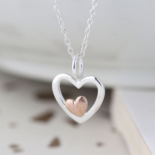 silver and rose gold heart necklace hanging 