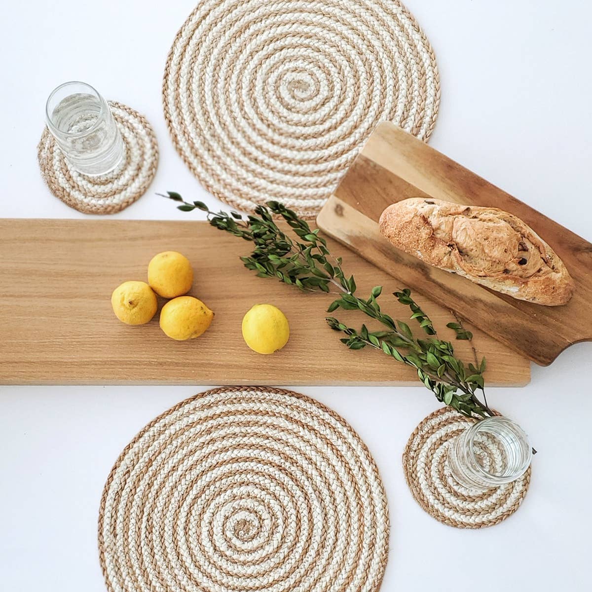 spiral placemats and coasters by wooden boards and greenery 