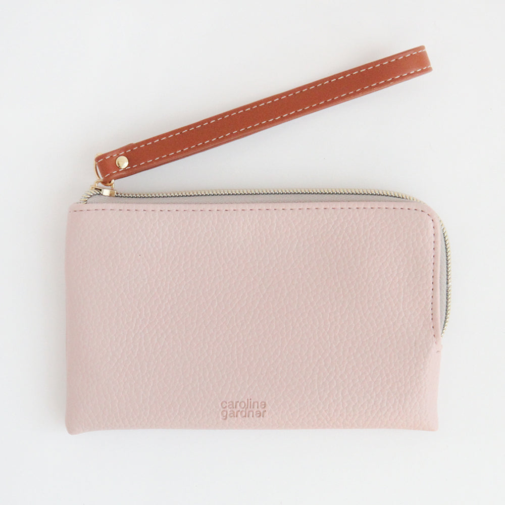 pale pink purse with brown leather handle on a white background 