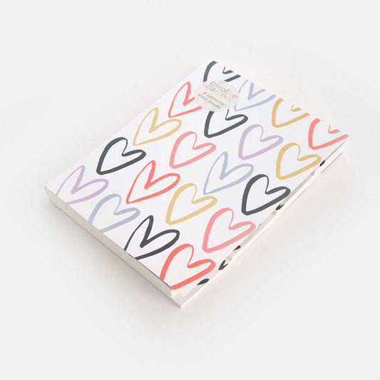 multi coloured heart notebook on white background